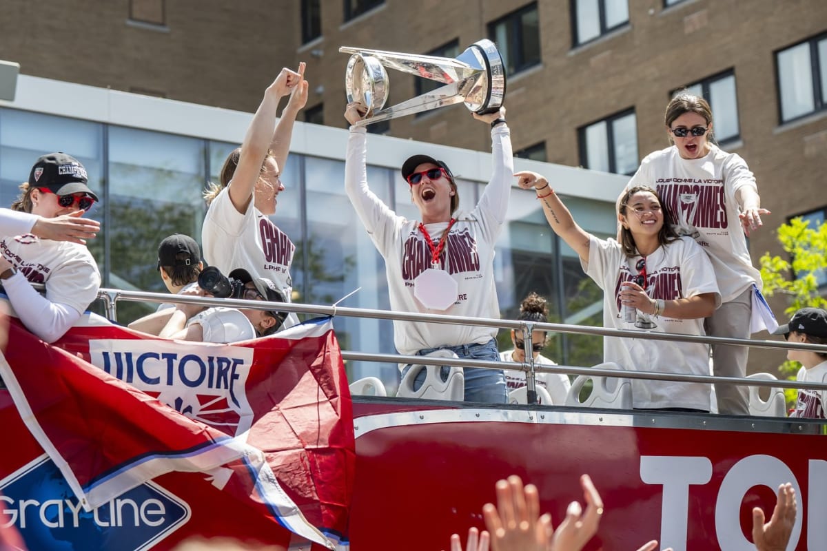 Montreal Victoire goaltender Ann-Renée Desbiens holds Walter Cup trophy surrounded by celebrating teammates