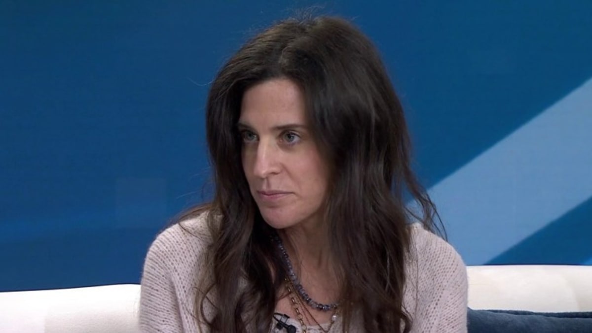 Jennifer Lava smiling while ringing the bell after completing chemotherapy treatment