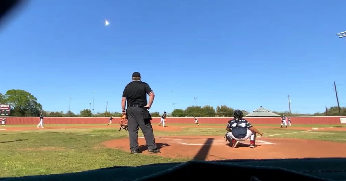 Bright meteor streaking across clear blue sky during youth baseball game in East Bernard, Texas