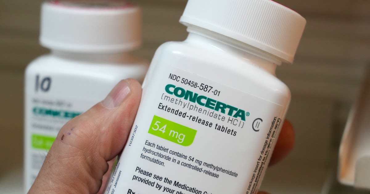 Young child taking medication with parent watching supportively in bright, hopeful home setting