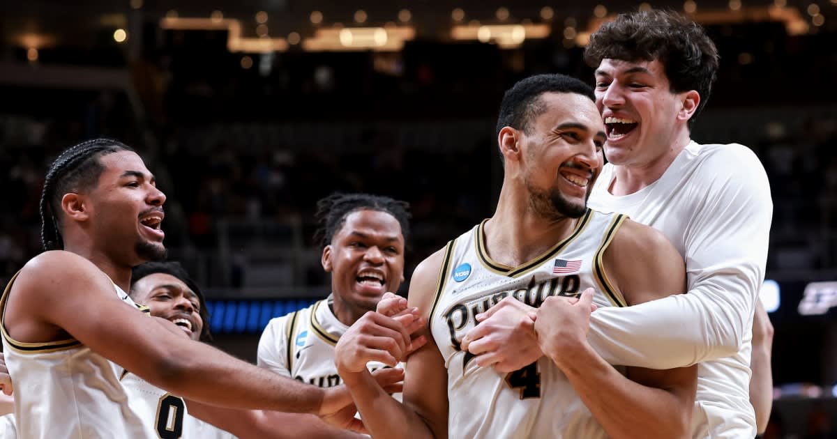 Purdue basketball player Trey Kaufman-Renn celebrates game-winning tip-in shot surrounded by teammates