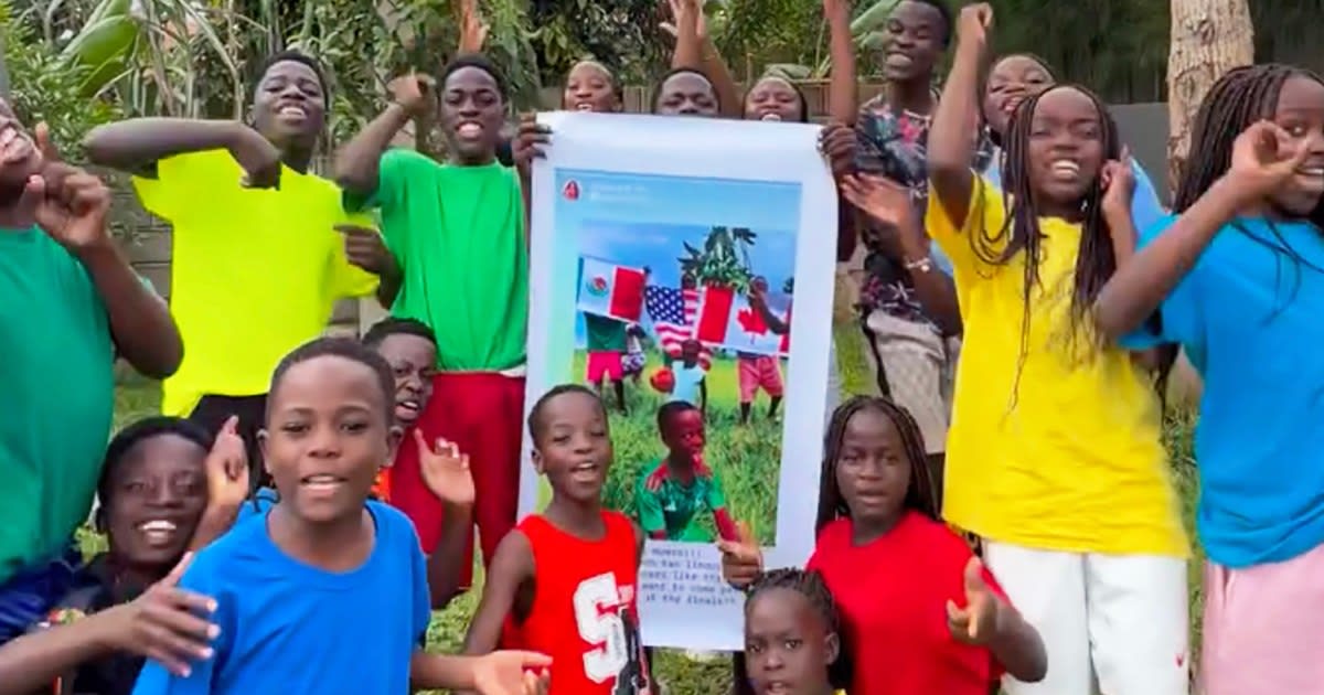 Ugandan Ghetto Kids dance troupe members smiling in matching green and purple jerseys