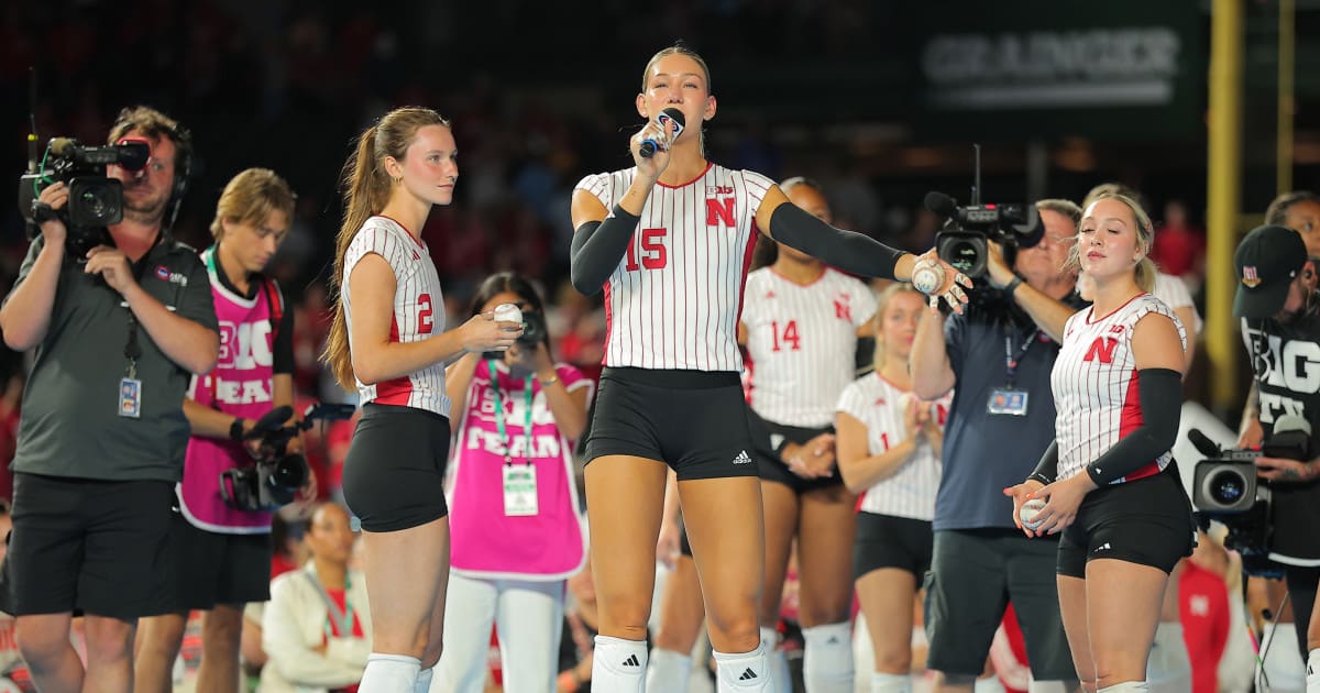 College volleyball players dancing together on outdoor court at Chicago's Wrigley Field during weather delay