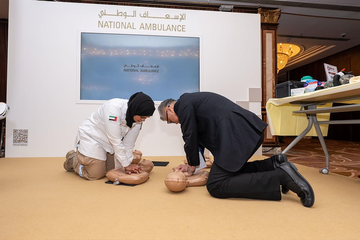** Visitors practice hands-only CPR techniques on training mannequins at Dubai emergency medical exhibition