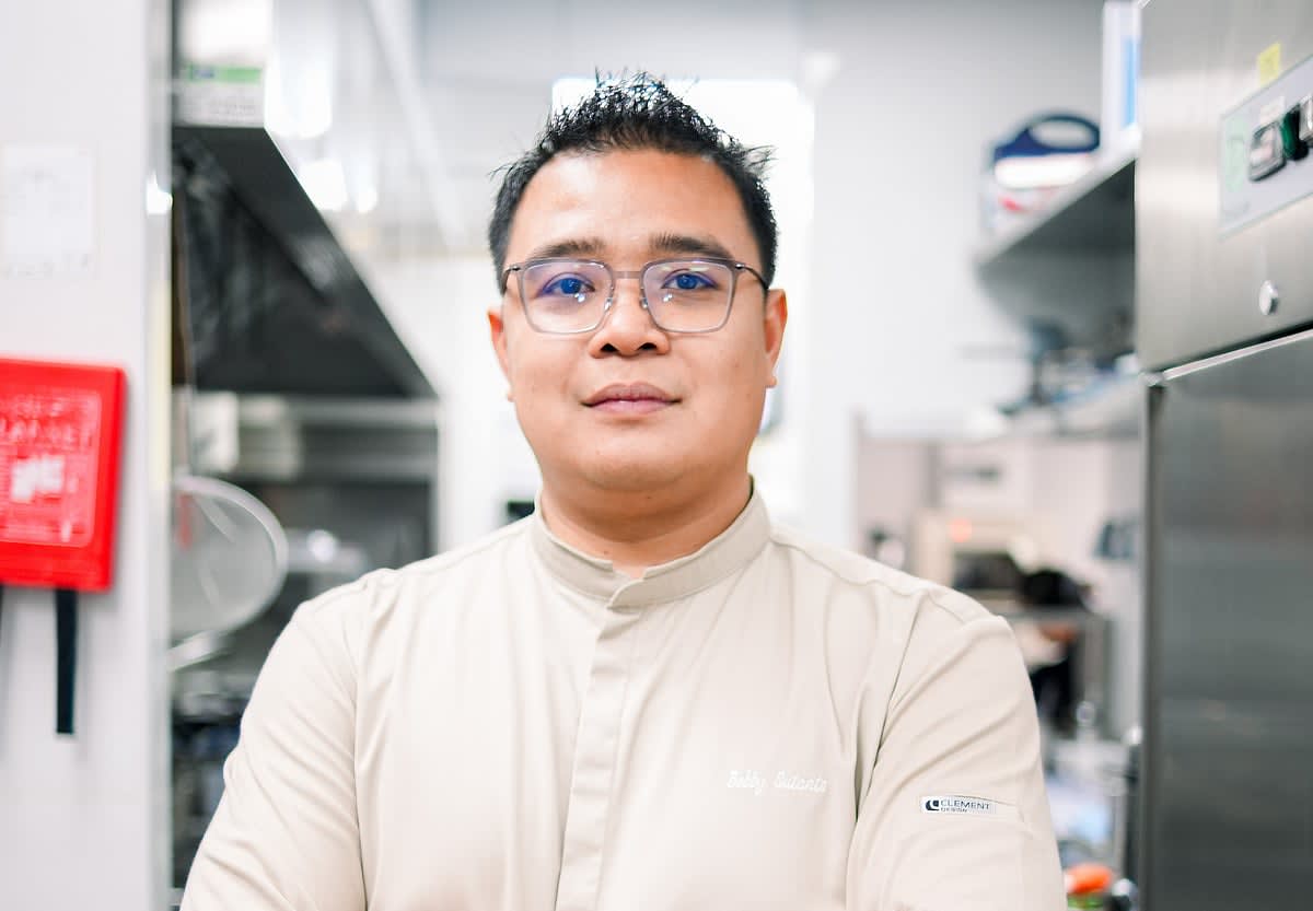 Indonesian chef Bobby Sutanto in professional kitchen uniform smiling at camera in Dubai