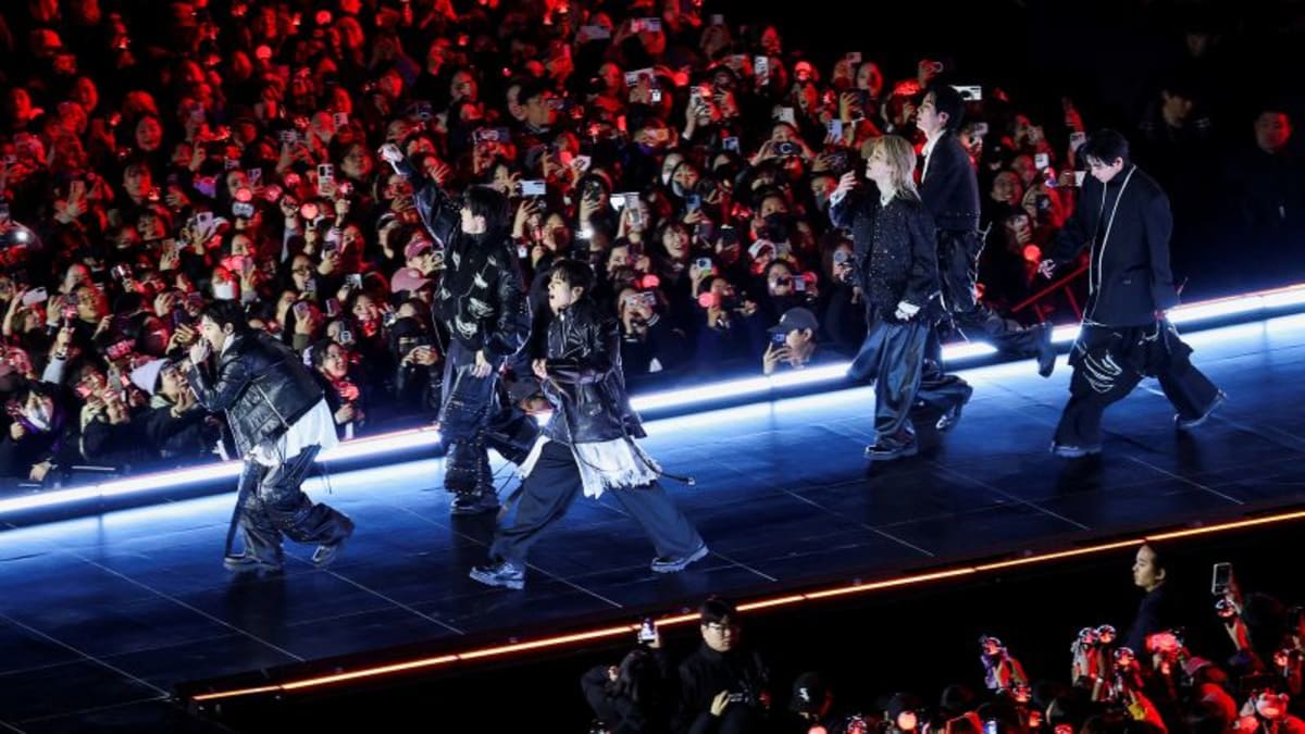 BTS performing on outdoor stage at historic Gwanghwamun Square in Seoul before massive crowd