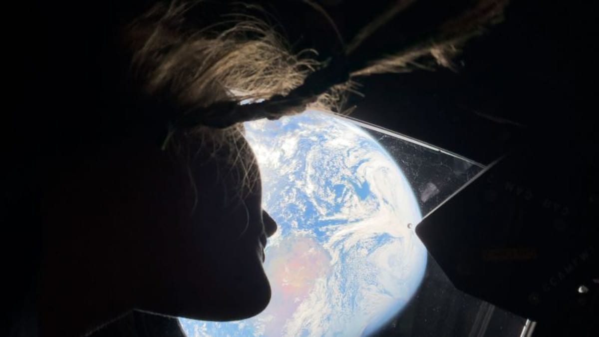 View of crescent Earth rising over lunar surface during Artemis II mission