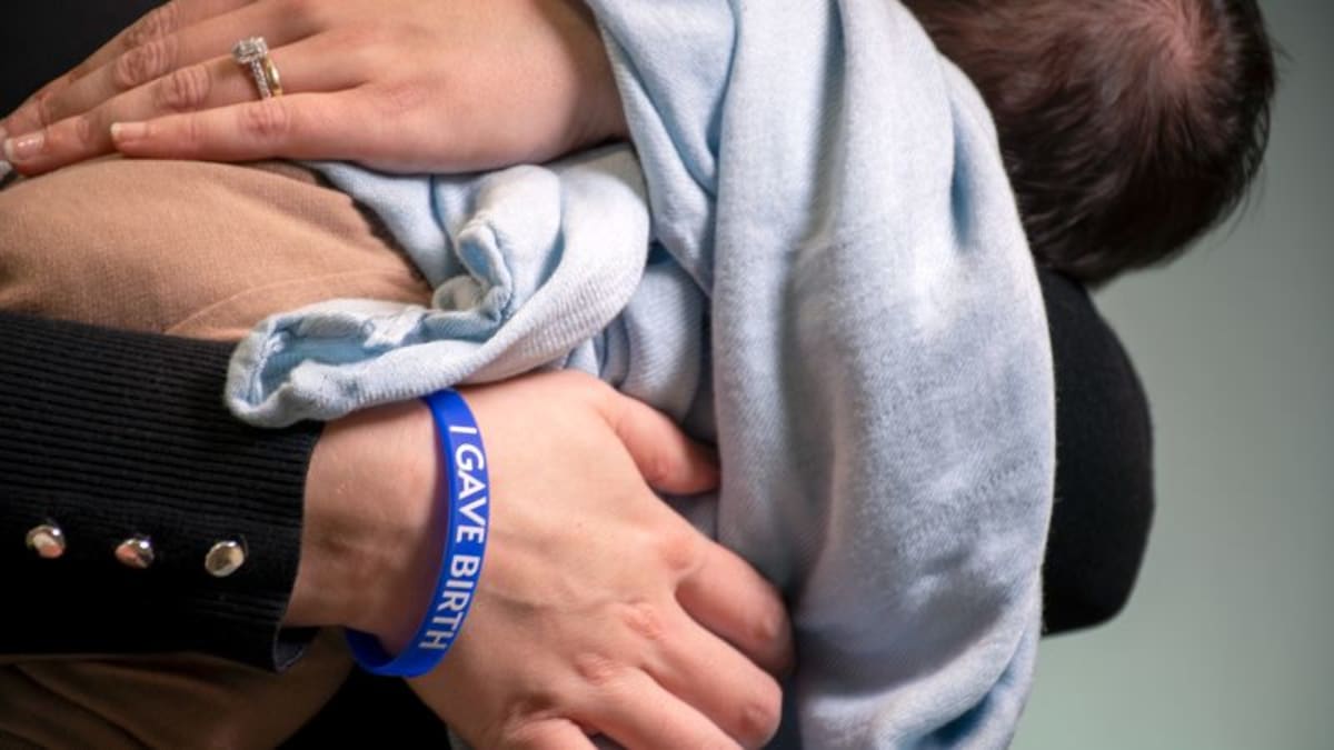Bright silicone wristband stamped with "I Gave Birth" text worn on woman's wrist