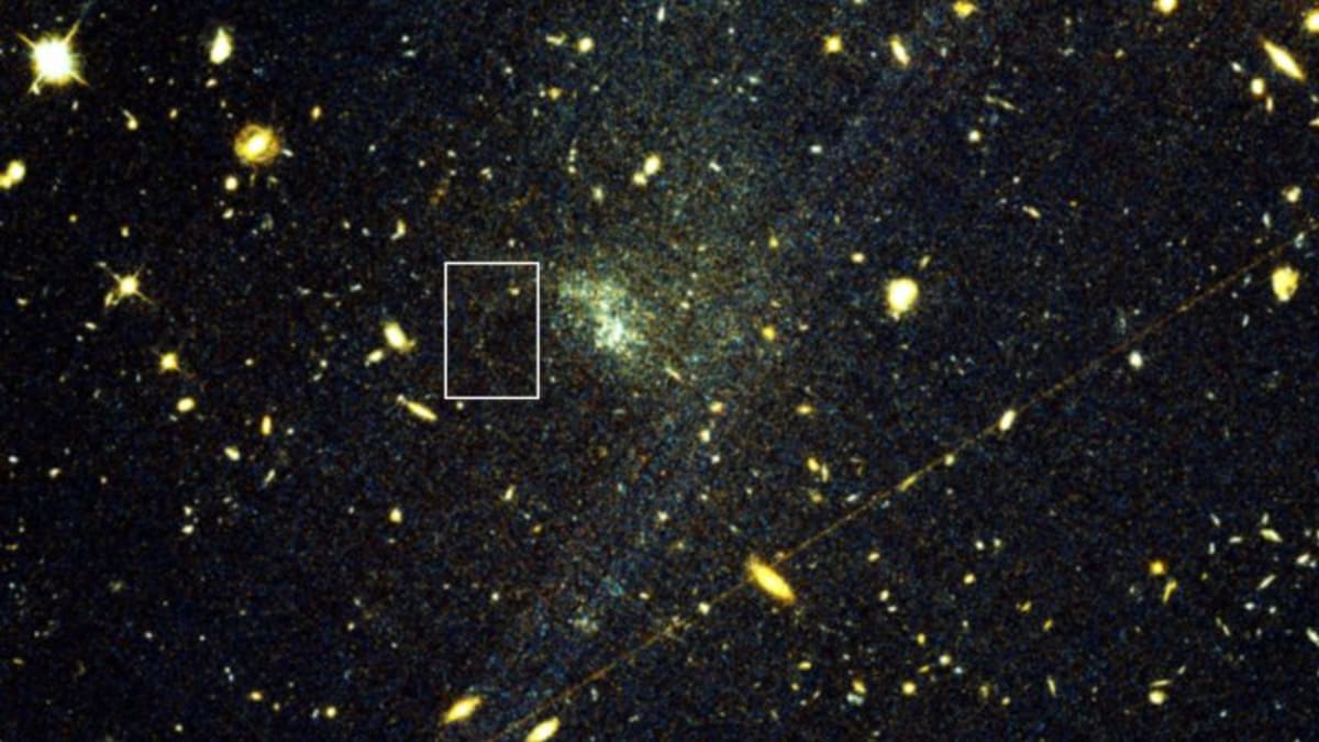 Hubble Space Telescope image showing faint trail of stars stretching across distant galaxy