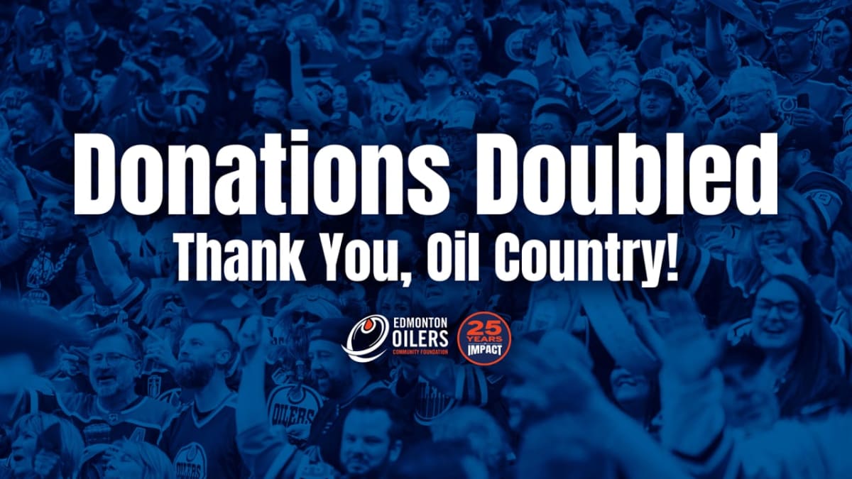 Edmonton Oilers fans and community foundation staff celebrating charitable giving milestone in Alberta