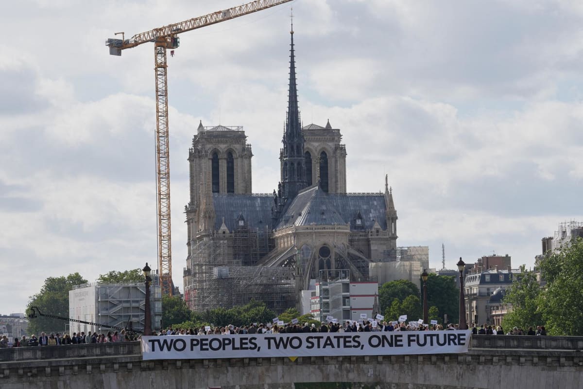 ** Israeli and Palestinian peace activists holding banners on Paris bridge supporting two-state solution