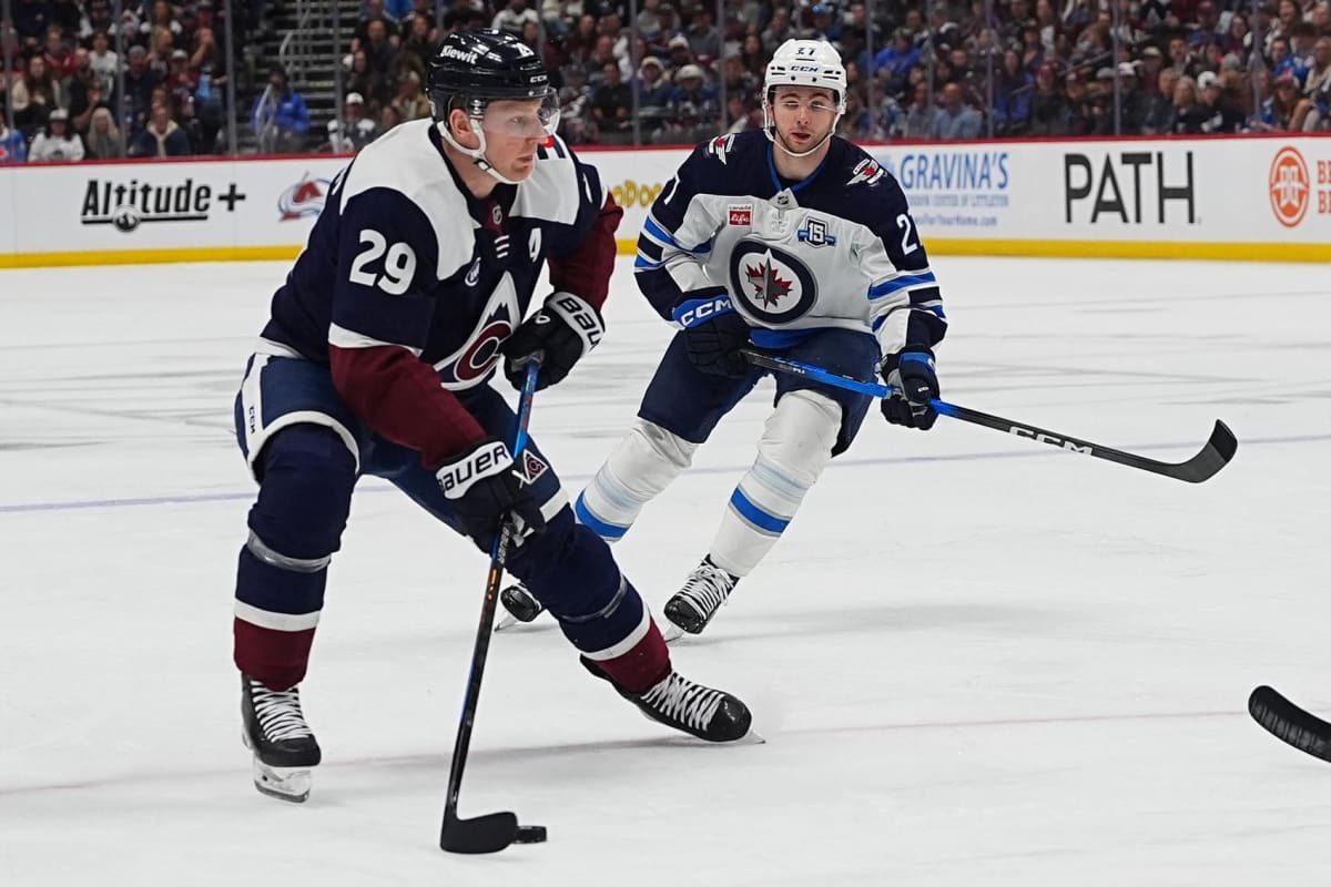 NHL hockey player Nathan MacKinnon skating with puck during Colorado Avalanche game