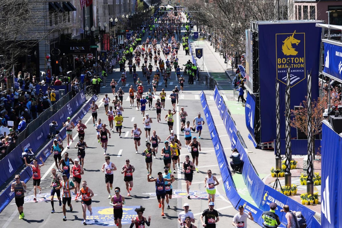 Large crowd of marathon runners approaching the finish line during Boston Marathon race