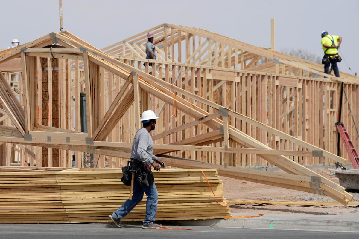 Construction workers building wooden roof frame on new home in Arizona suburb