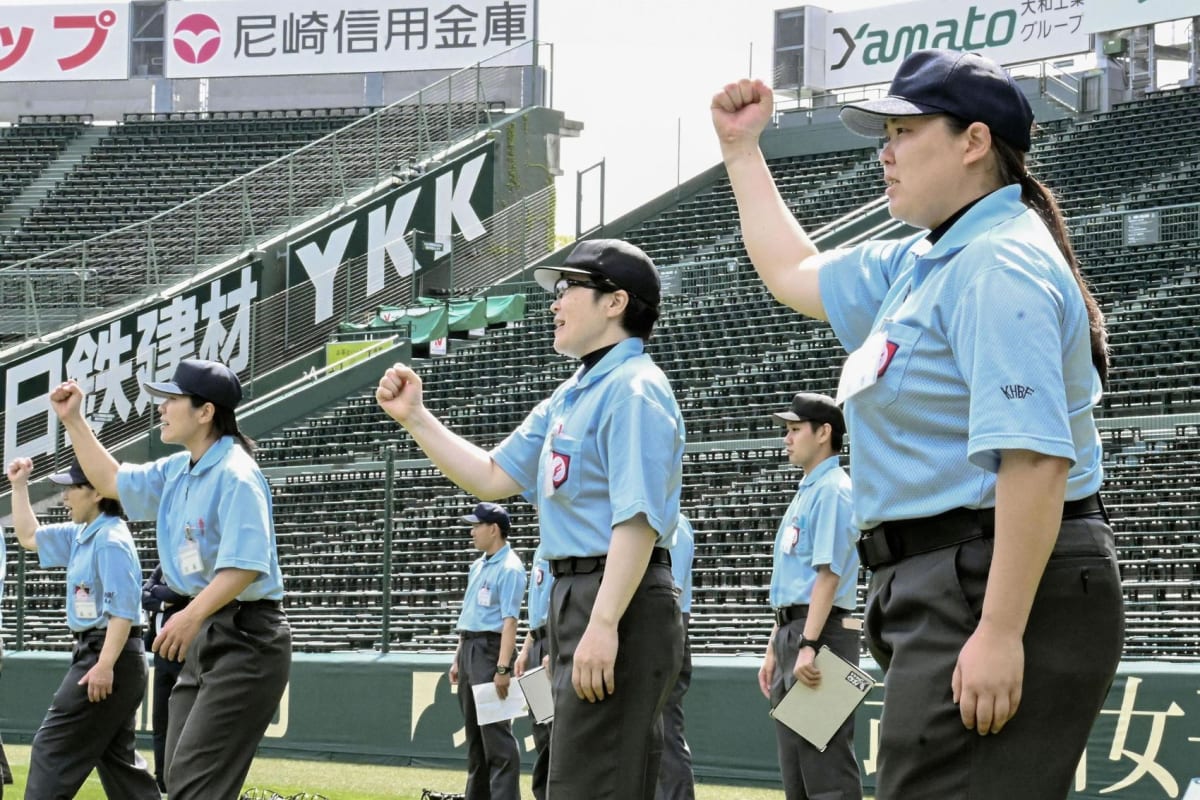 Female baseball umpires in uniform training on the field at Koshien Stadium in Japan