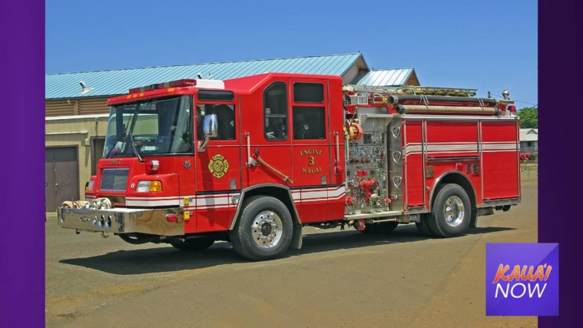 Kauai firefighters carrying rescue litter on scenic Hawaiian hiking trail with lush greenery