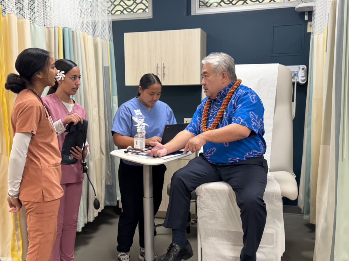Students in medical scrubs practice healthcare skills in modern simulated hospital lab at Wai'anae High School
