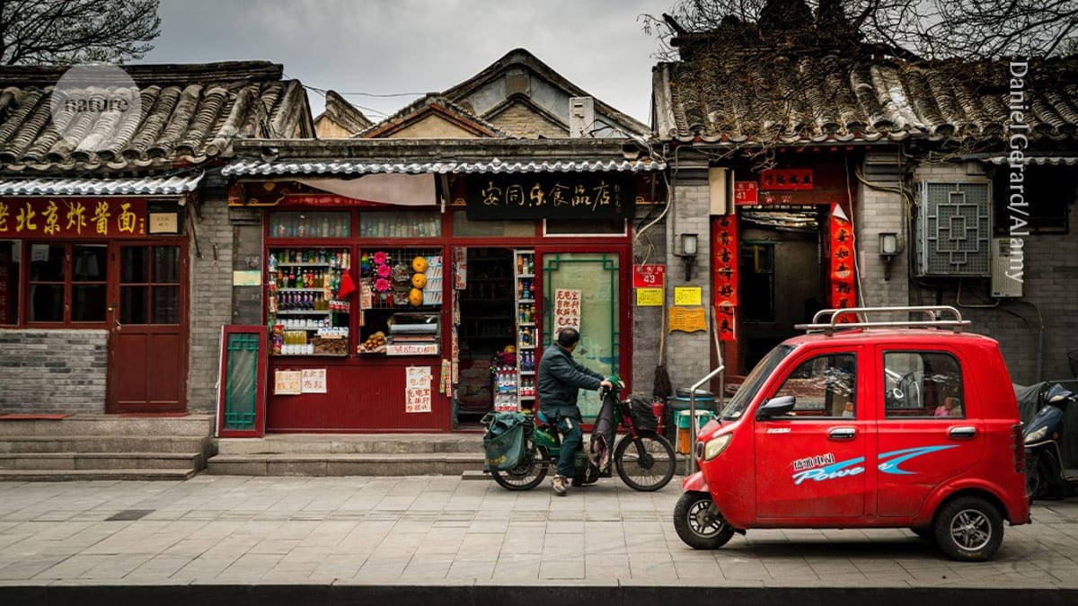 Small compact electric vehicle on Chinese street carrying passengers for daily errands