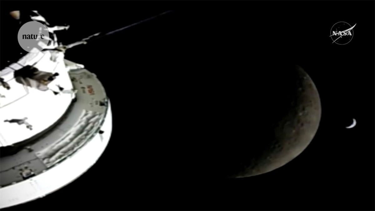 View of the Moon's surface from Orion capsule with Earth visible in background during Artemis II flyby