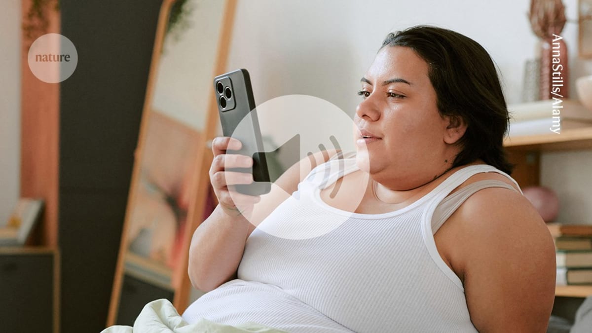 Person holding smartphone pointed at their face for heart rate monitoring measurement