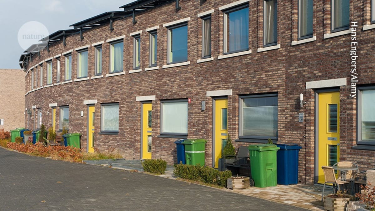 Dutch household separating colorful plastic waste into different recycling bins at home