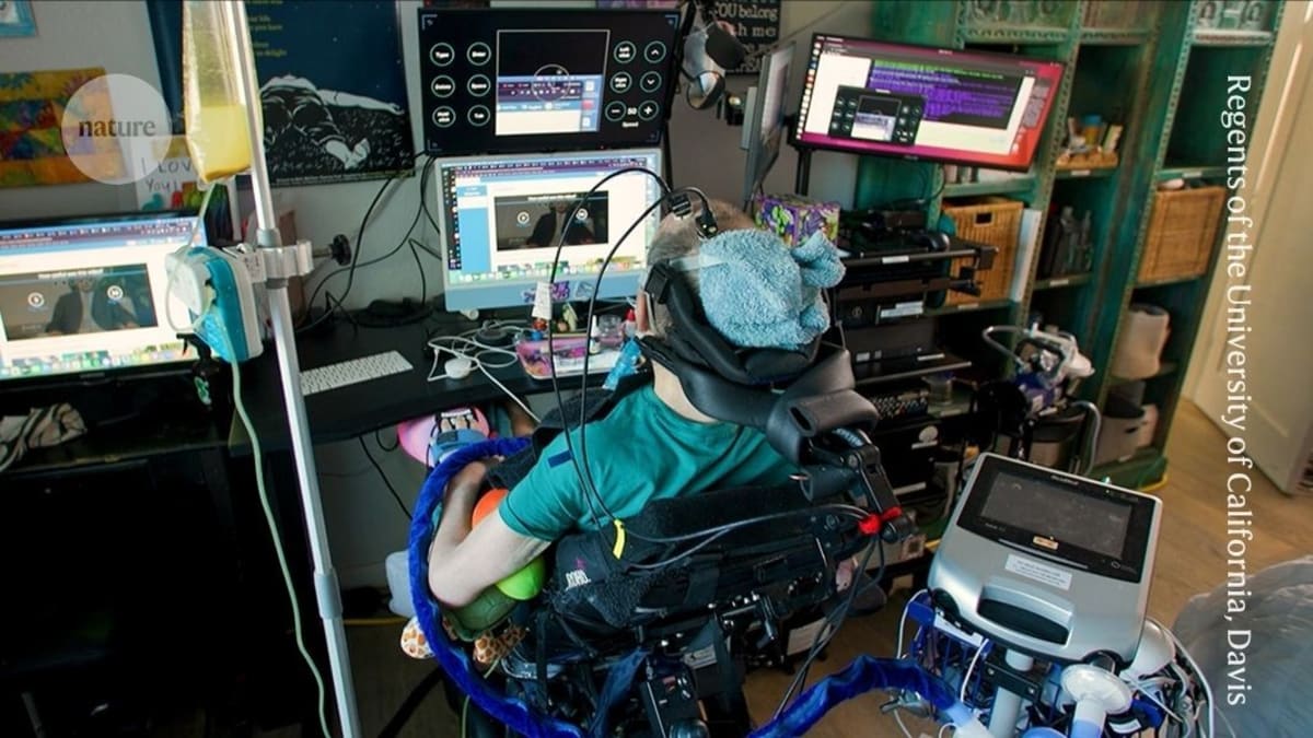 Man using brain-computer interface system at home with electrodes connected to computer screen