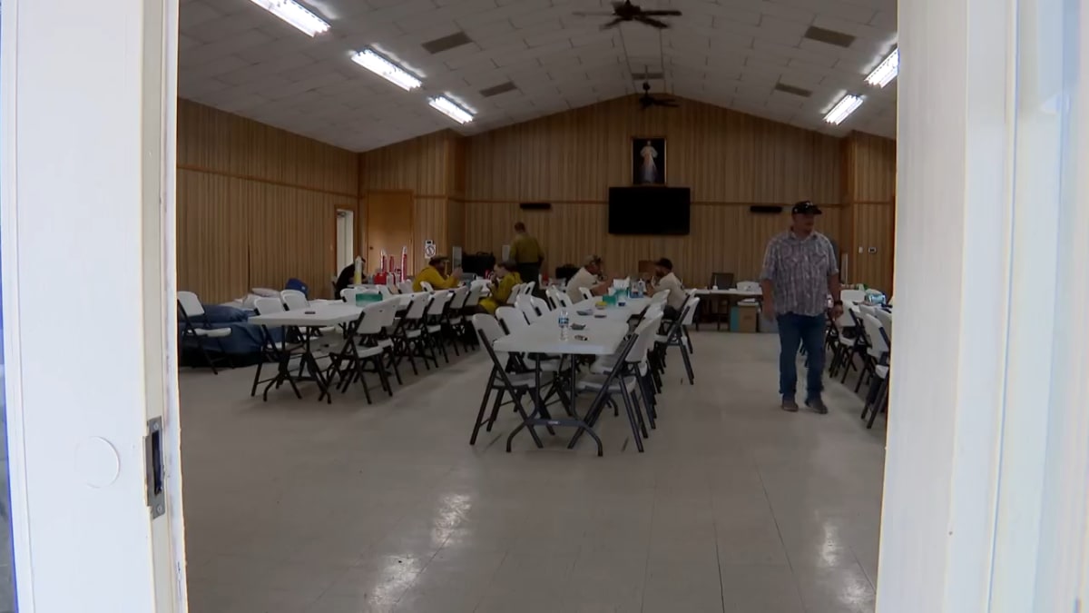 Volunteers preparing meals and supplies inside church assembly room for Texas wildfire firefighters