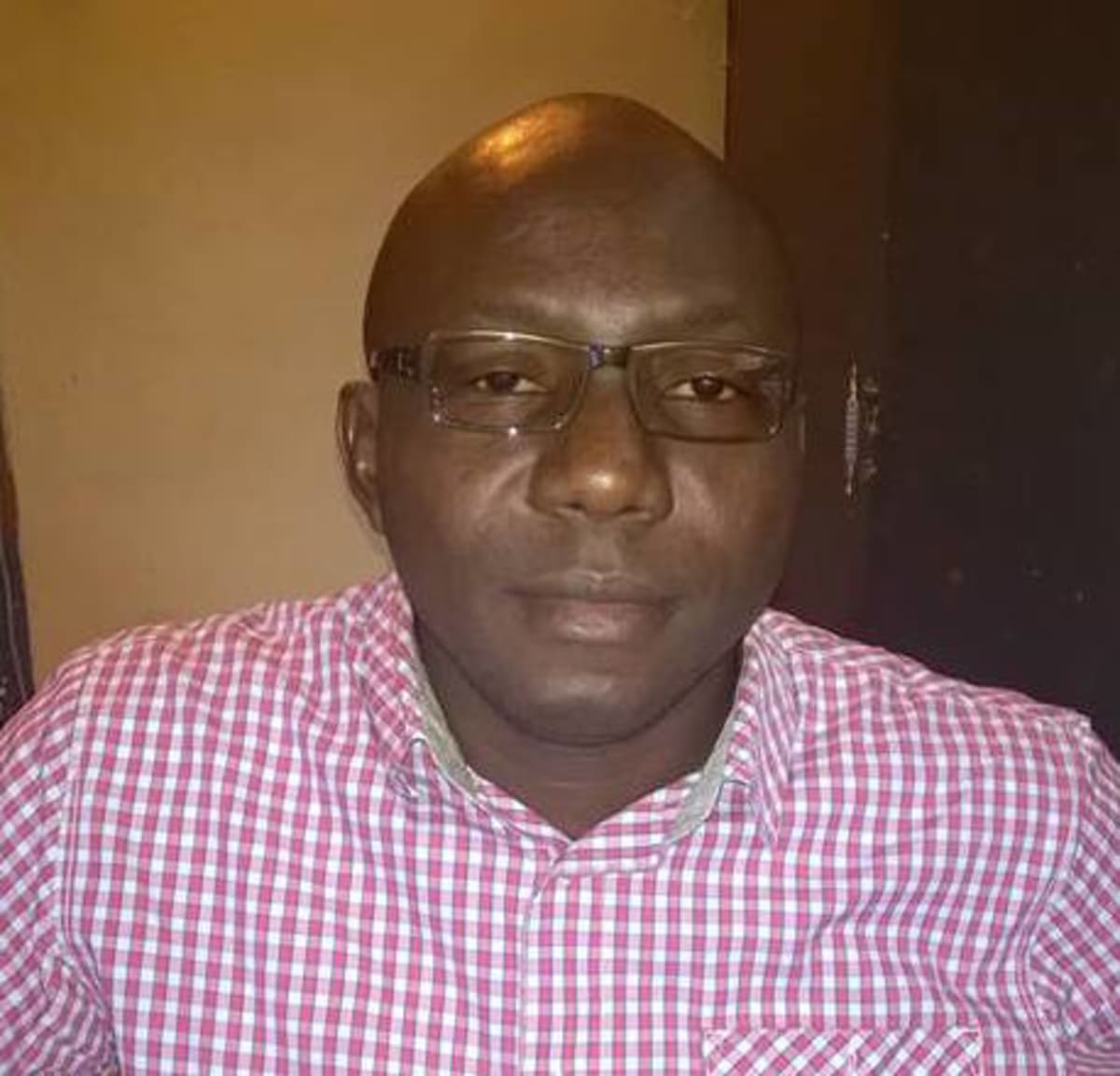 ** Nigerian Ambassador Ifeanyi Ugwuanyi smiling in formal diplomatic attire representing his country in Greece