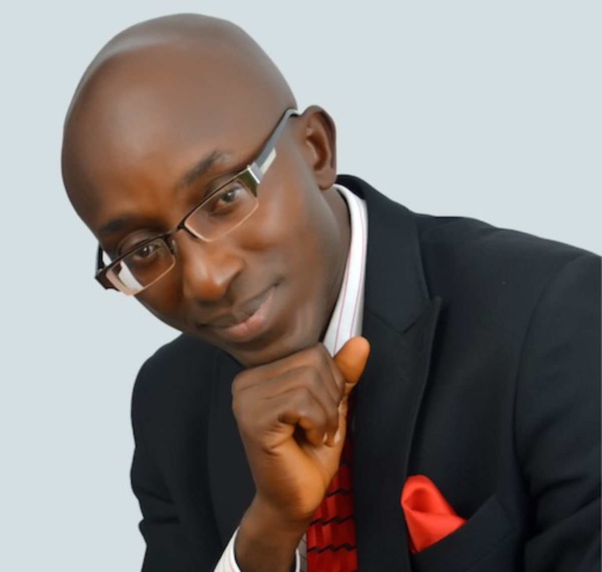Nigerian pharmacist writing at desk with medical books and laptop showing professional development journey