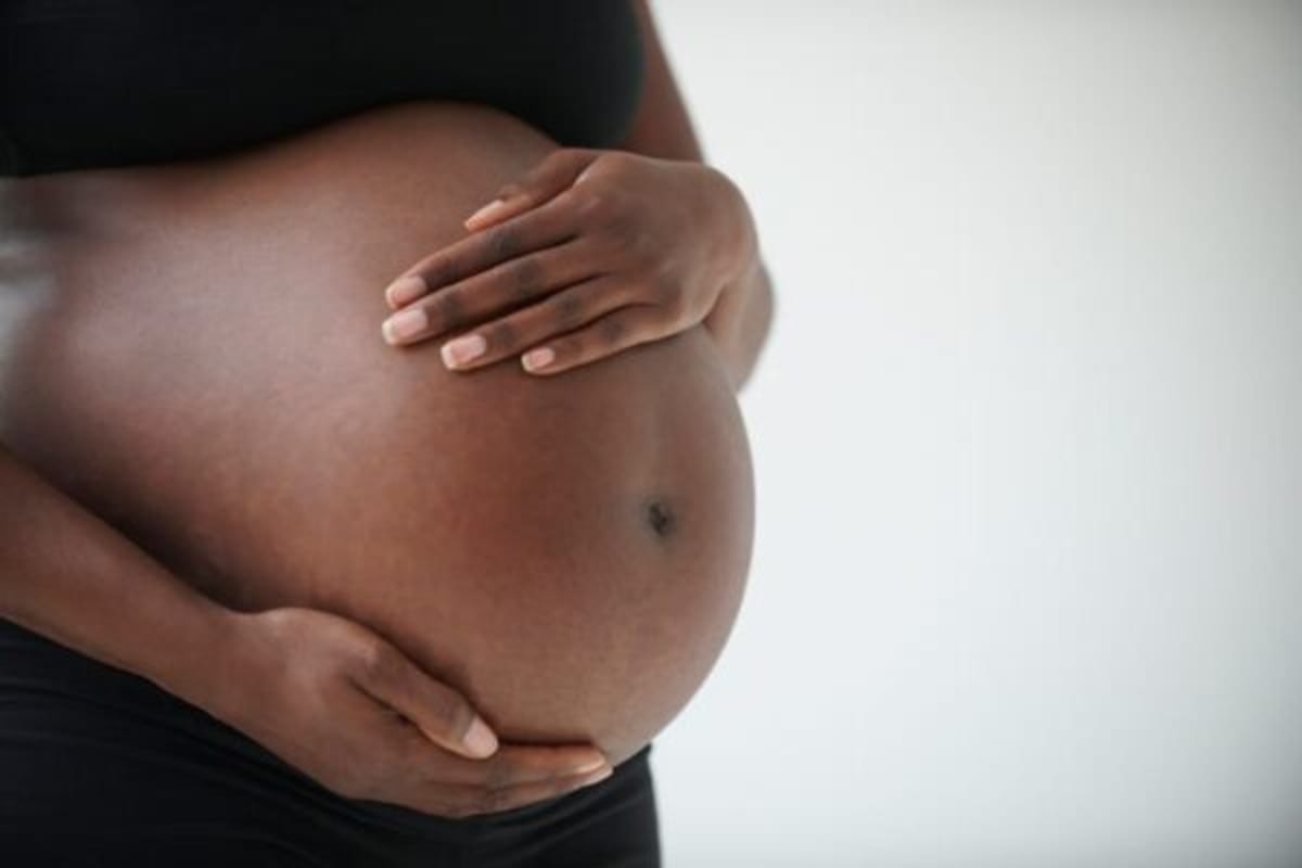 Nigerian pregnant woman receiving medical care from healthcare provider in hospital setting