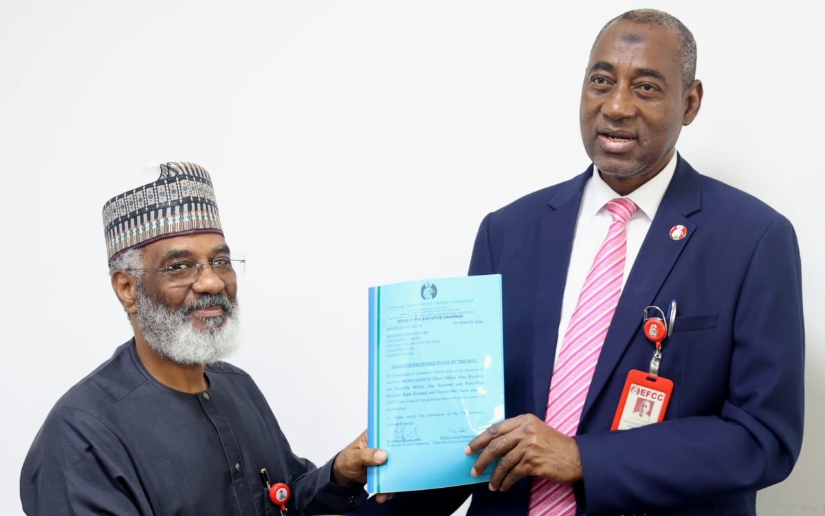 ** Officials shaking hands during formal handover ceremony of recovered funds at EFCC headquarters in Abuja, Nigeria
