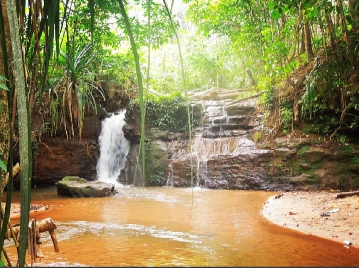 Scenic waterfall surrounded by lush Nigerian vegetation at Arochukwu heritage tourism site
