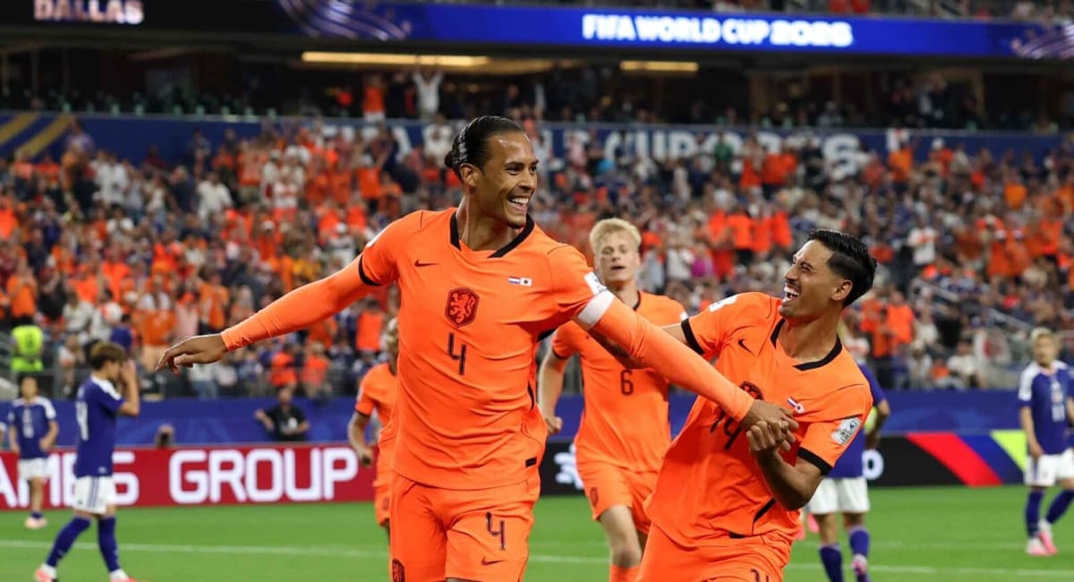 Japanese and Dutch soccer players compete during intense World Cup qualifying match action