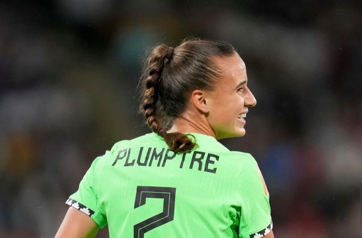Ashleigh Plumptre in Nigerian Super Falcons jersey celebrating with teammates on soccer field