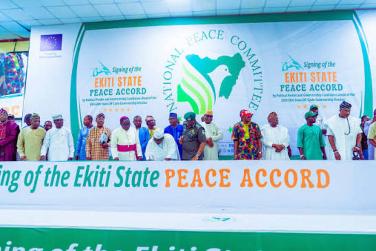 Political party representatives signing peace accord document at table in Osun State Nigeria