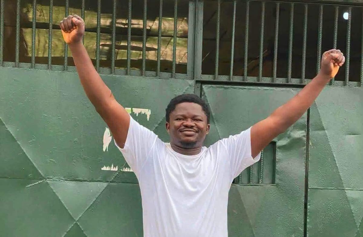 Denis Odama standing outside correctional facility gates in Calabar, Nigeria after his release