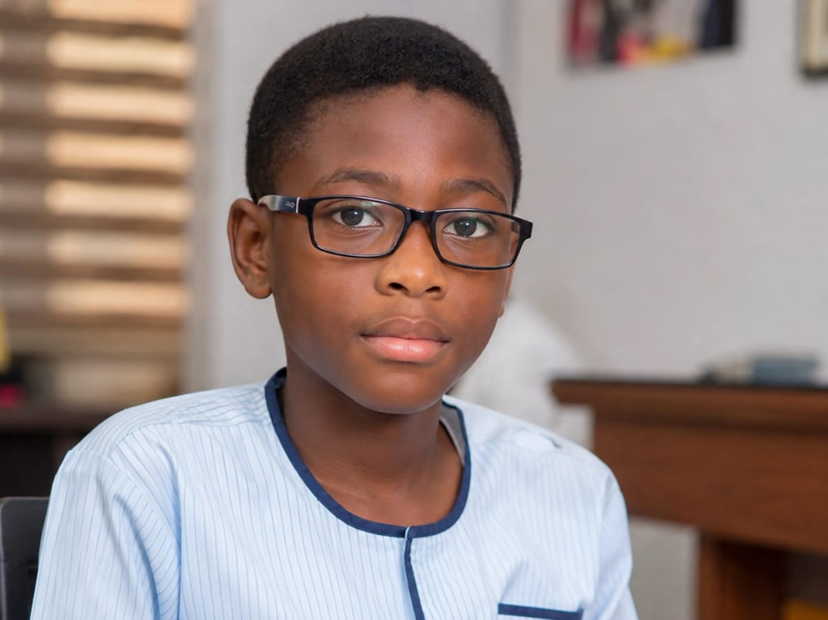 Young child getting eye exam from optometrist in bright, modern clinic setting