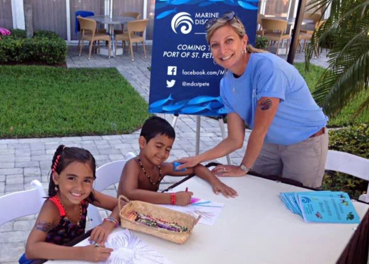 Volunteers working with marine animals at aquarium tanks in St. Petersburg Marine Exploration Center