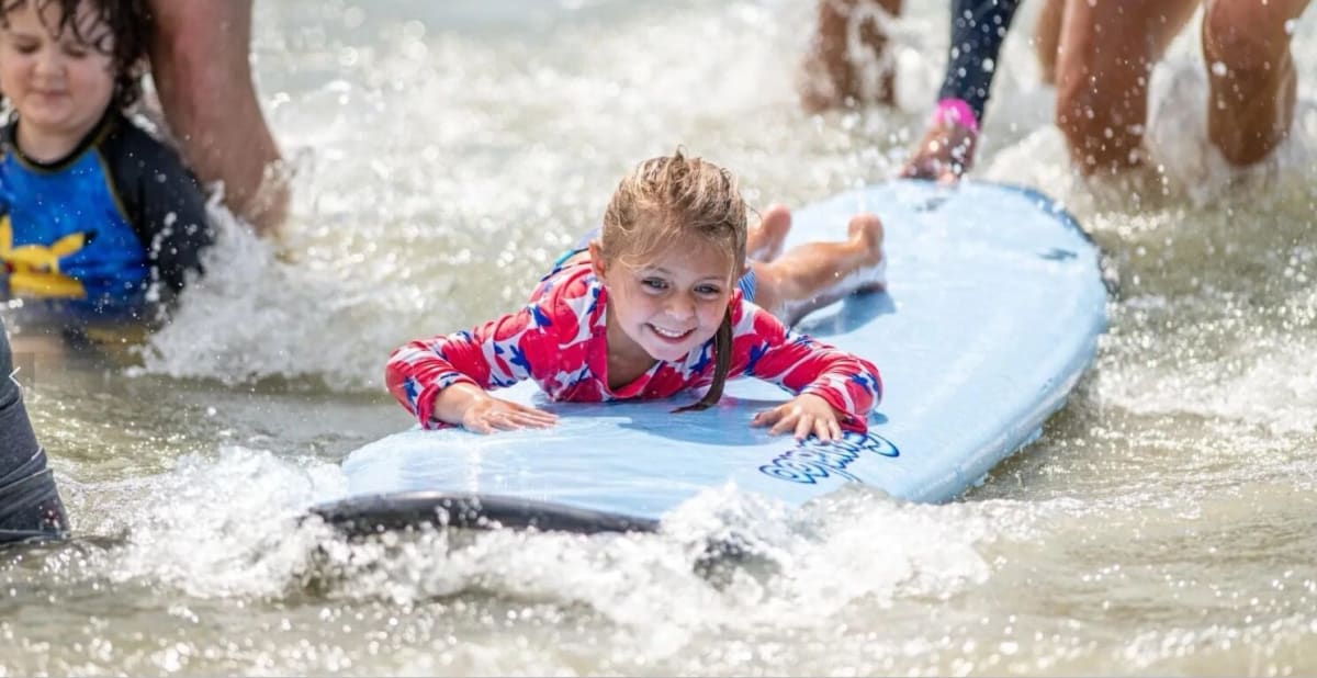 ** Volunteers helping children with autism surf at St Pete Beach festival