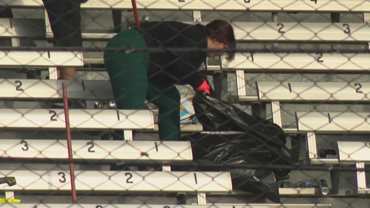 ** Volunteers in bright vests cleaning Indianapolis Motor Speedway grandstands after Indy 500 race