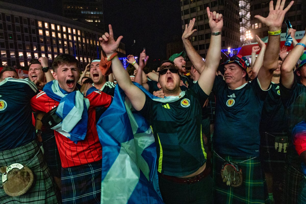 Scottish soccer fans wave from yellow school bus windows heading to World Cup match