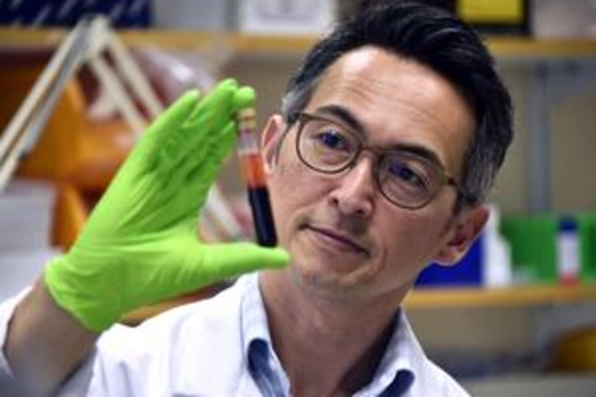 Researcher Lao Saal in laboratory holding blood test sample used for early cancer detection