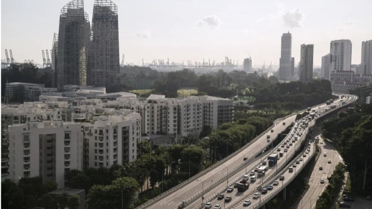Traffic flowing smoothly on Singapore's West Coast Highway with modern city skyline in background