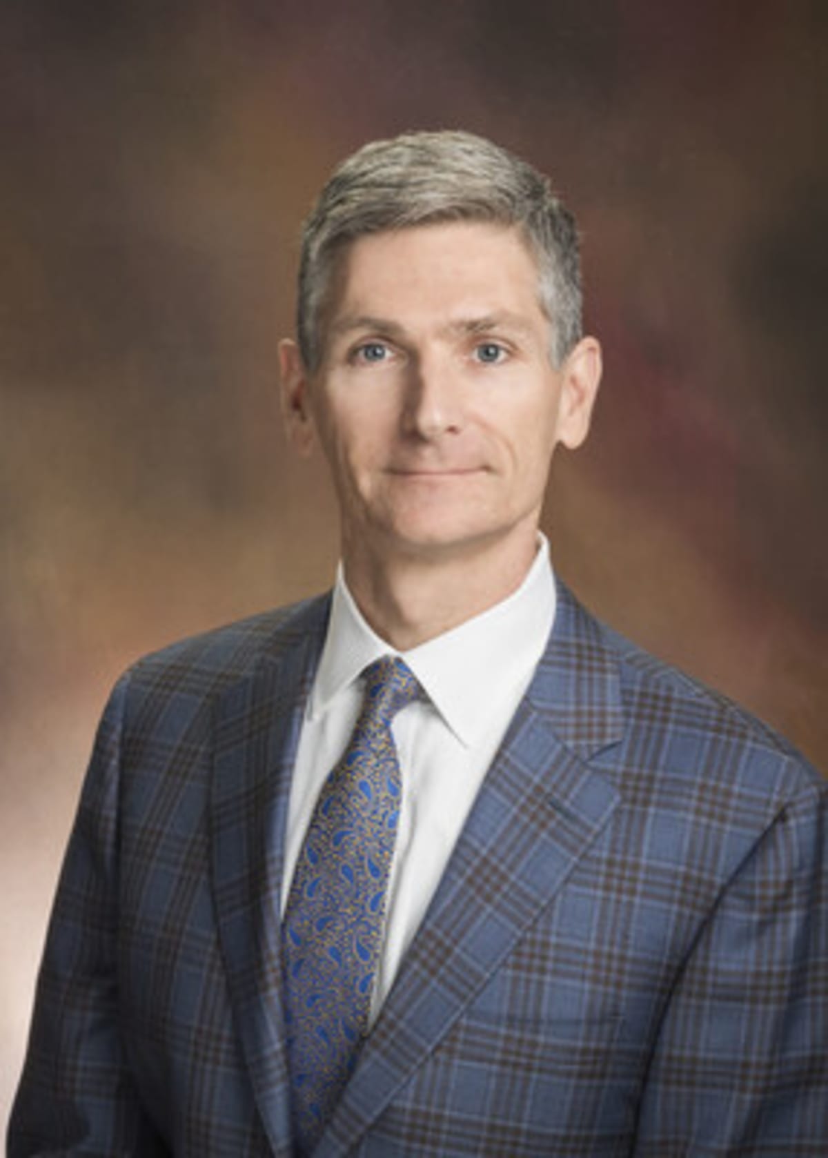 ** Smiling teenager with stethoscope held to chest by doctor in bright medical office