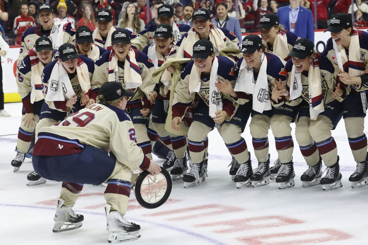 Montreal Victoire players celebrate on ice holding Walter Cup trophy after championship victory