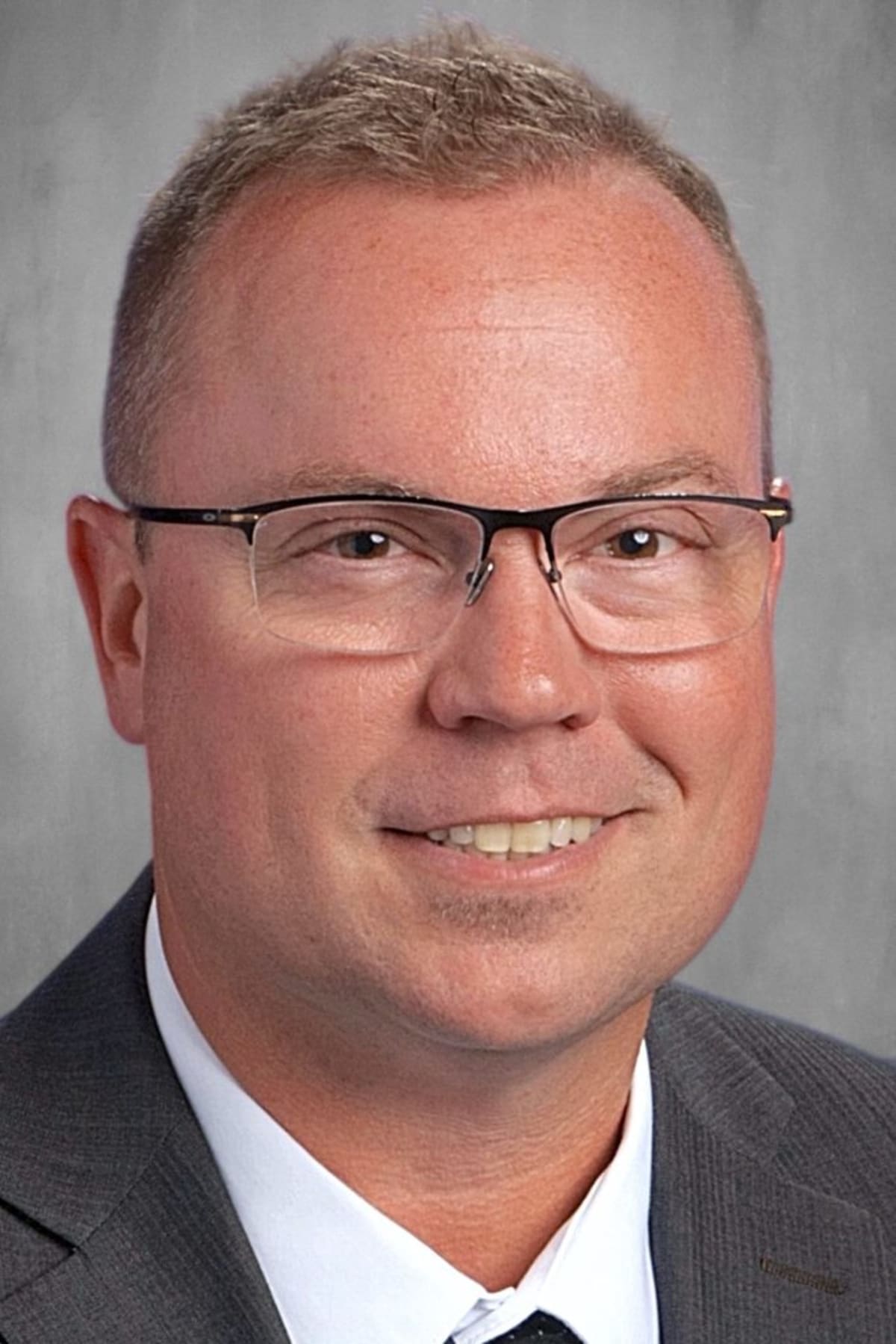 High school students studying together in classroom with teacher providing personalized academic support