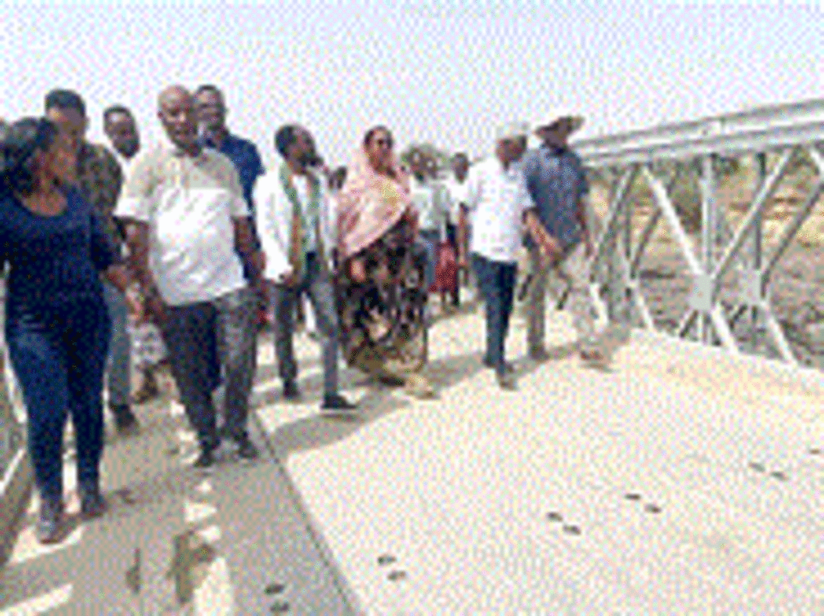 New gravel road and steel bridge cutting through rural Ethiopian landscape in Afar Region