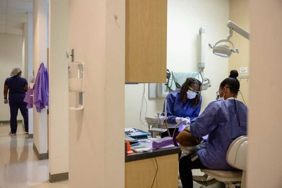 ** Dental assistant helping dentist provide care at community health center in New Orleans