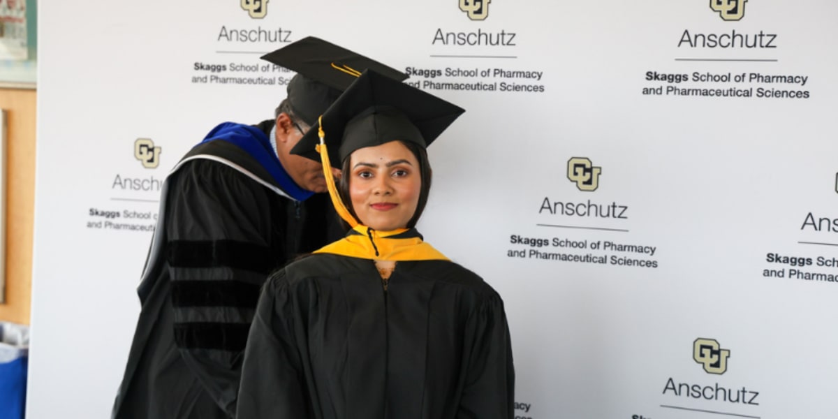 Pharmacy graduate students in academic regalia celebrating at University of Colorado Anschutz hooding ceremony