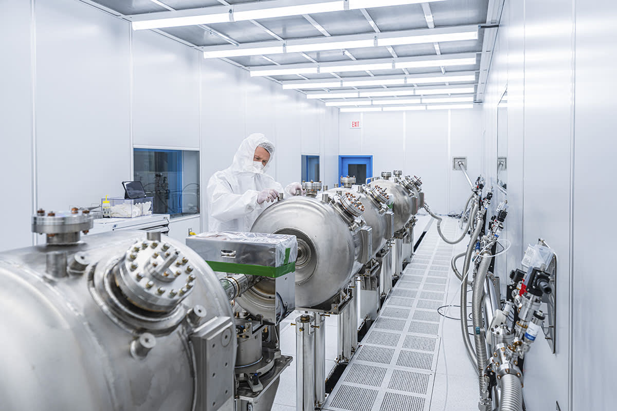 Scientists in control room monitoring superconducting particle accelerator equipment at Fermilab research facility